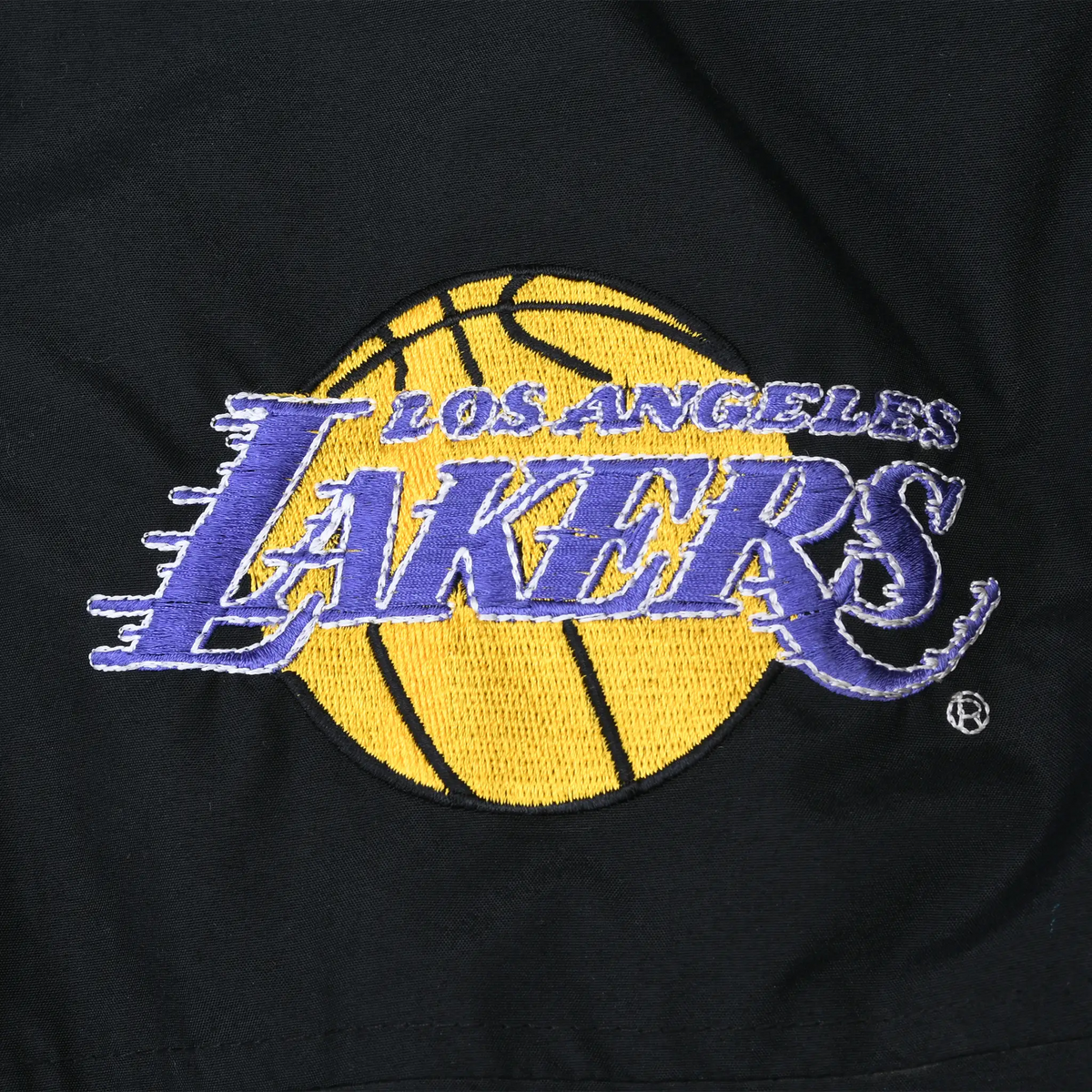 Close-up of purple and gold Los Angeles Lakers logo embroidery on black jacket chest