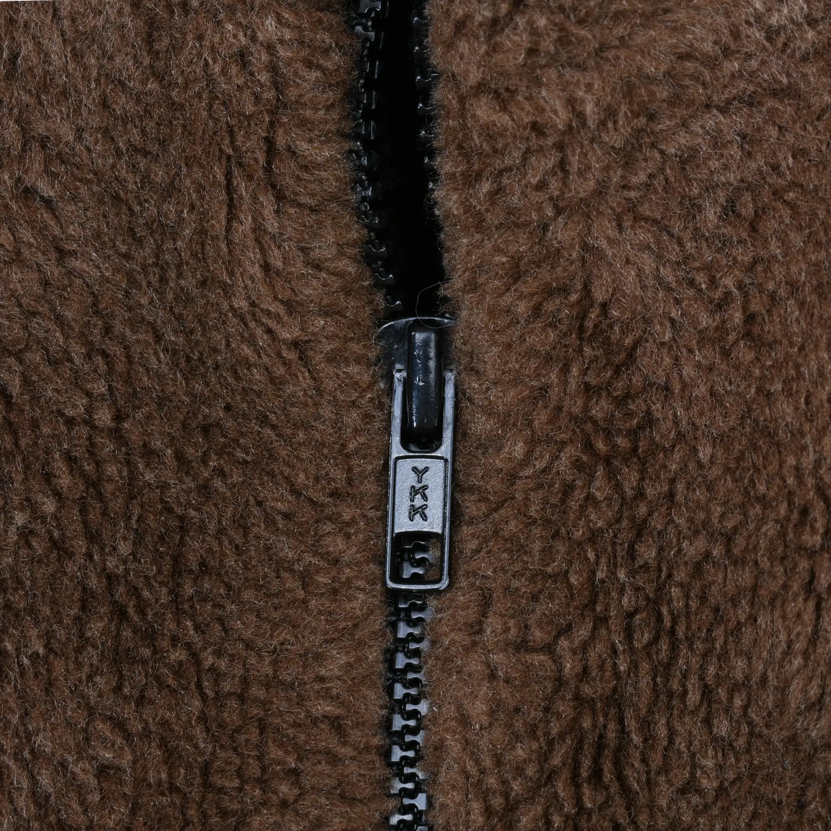 Close-up of black YKK zipper on brown fleece fabric