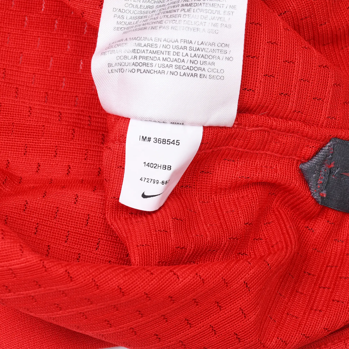 Interior care and item number tags against red perforated jersey fabric