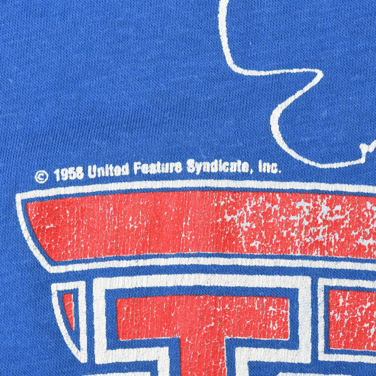 Close-up of distressed red print and United Feature Syndicate copyright text