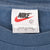 Nike neck tag marked size large and Made in U.S.A. inside blue-grey T-shirt