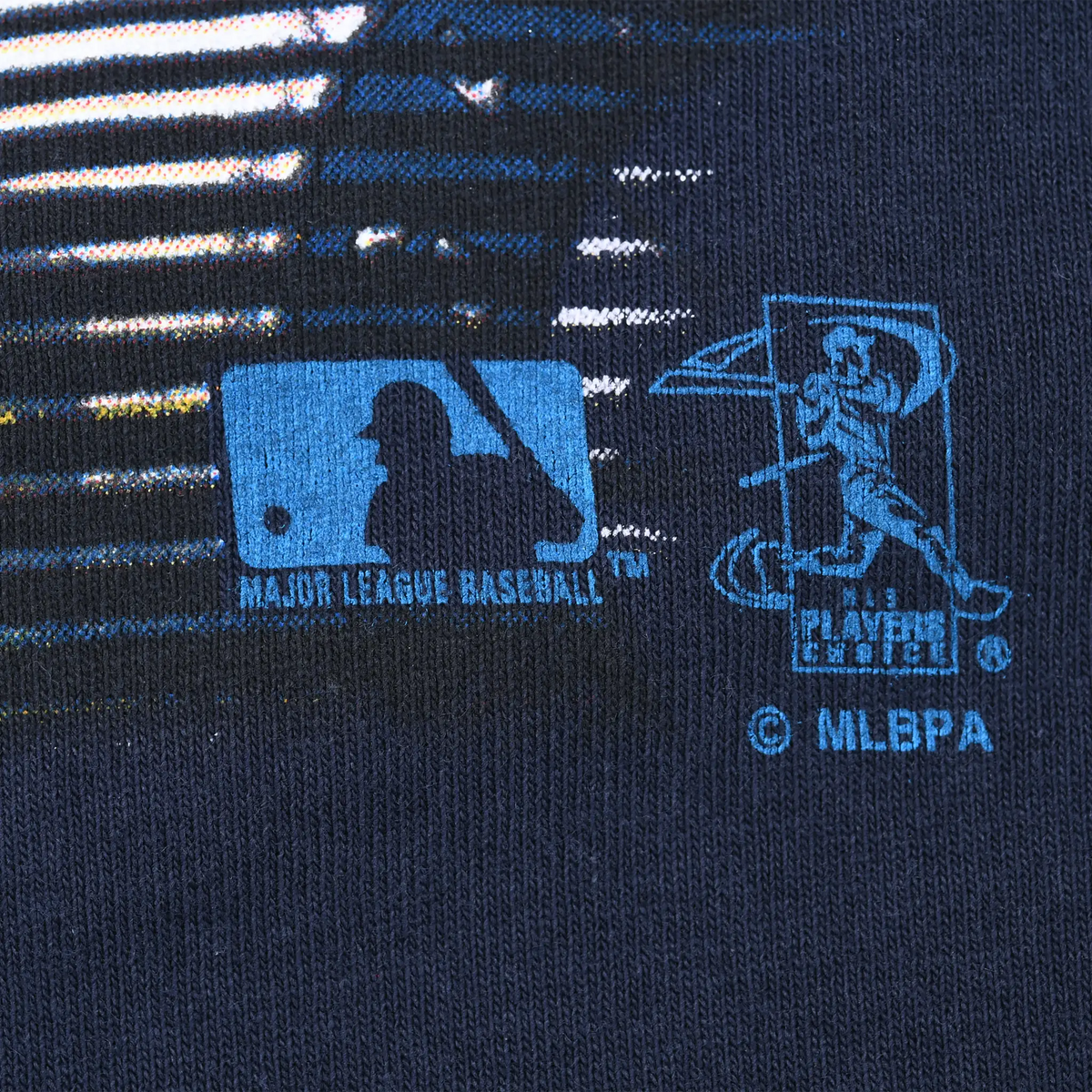 Close-up of MLB and MLBPA logos printed in blue on navy fabric