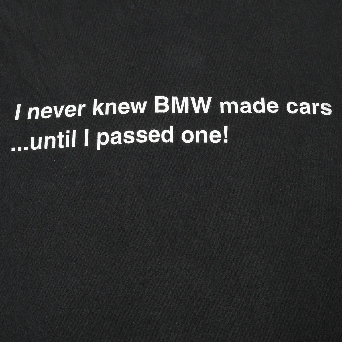 Close-up of back print reading “I never knew BMW made cars ...until I passed one!”