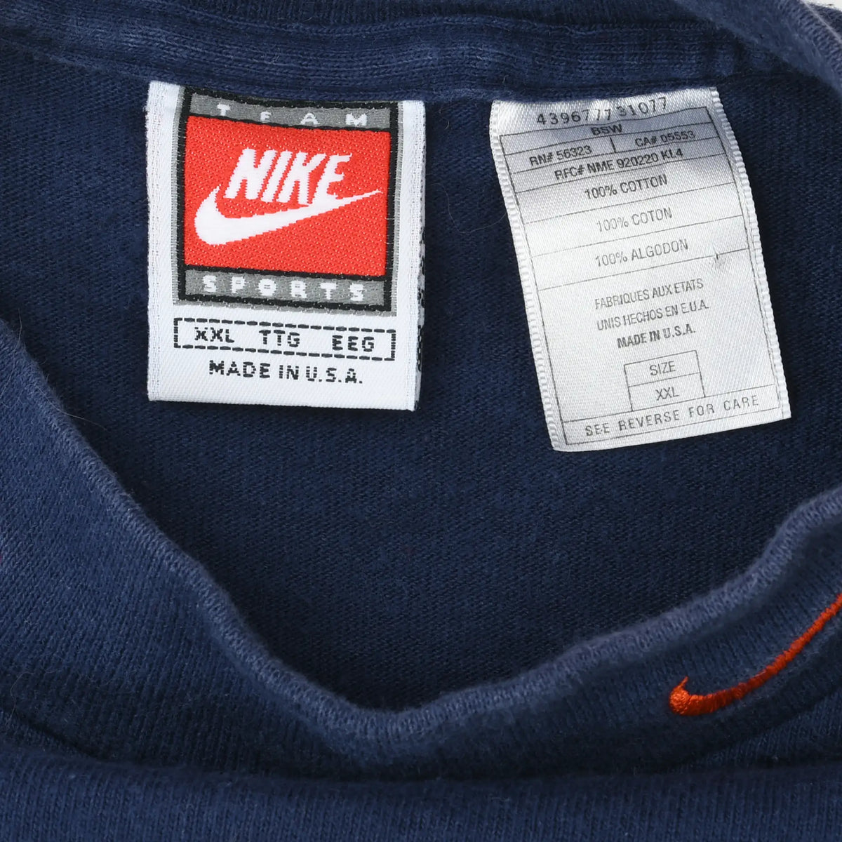 Close-up of Nike Sports XXL neck tag and care label inside navy turtleneck shirt
