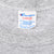 Close-up of the Champion Large neck tag and collar stitching on the gray T-shirt
