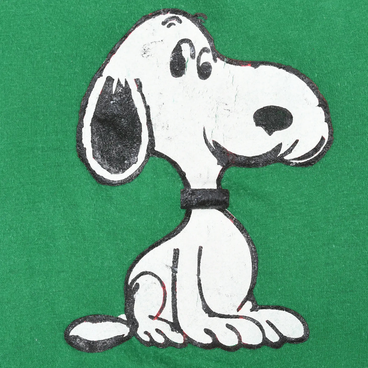 Close-up of seated Snoopy print on green T-shirt