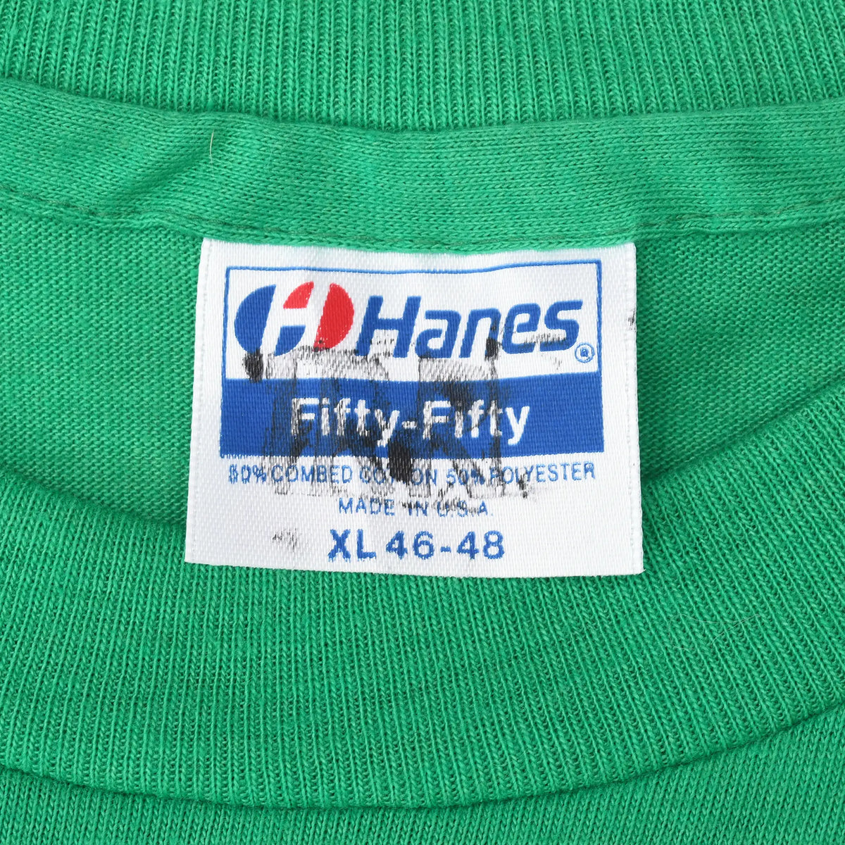 Close-up of Hanes Fifty-Fifty XL 46-48 neck tag on green T-shirt