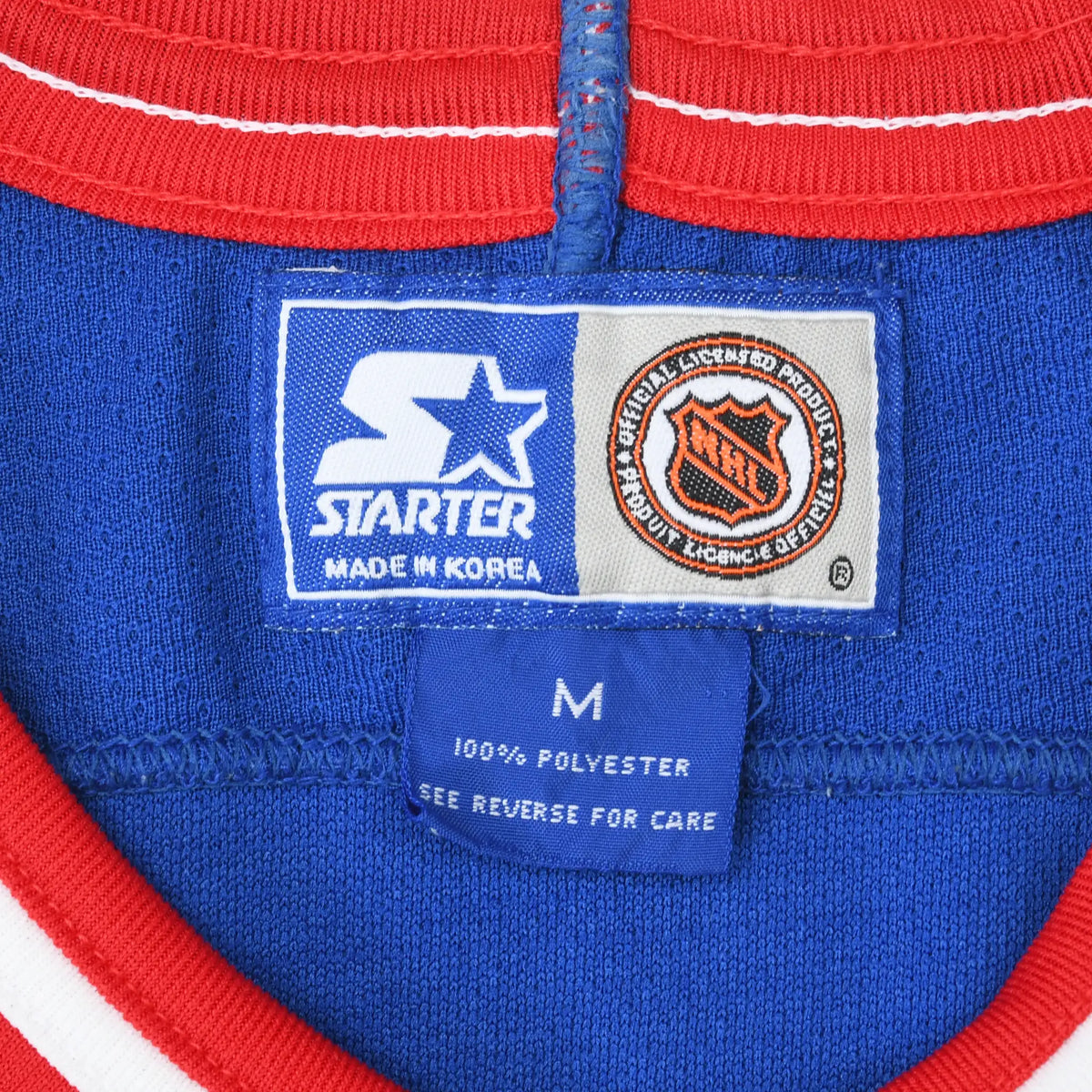 Close-up of Starter and NHL neck labels with medium size tag inside blue Rangers jersey