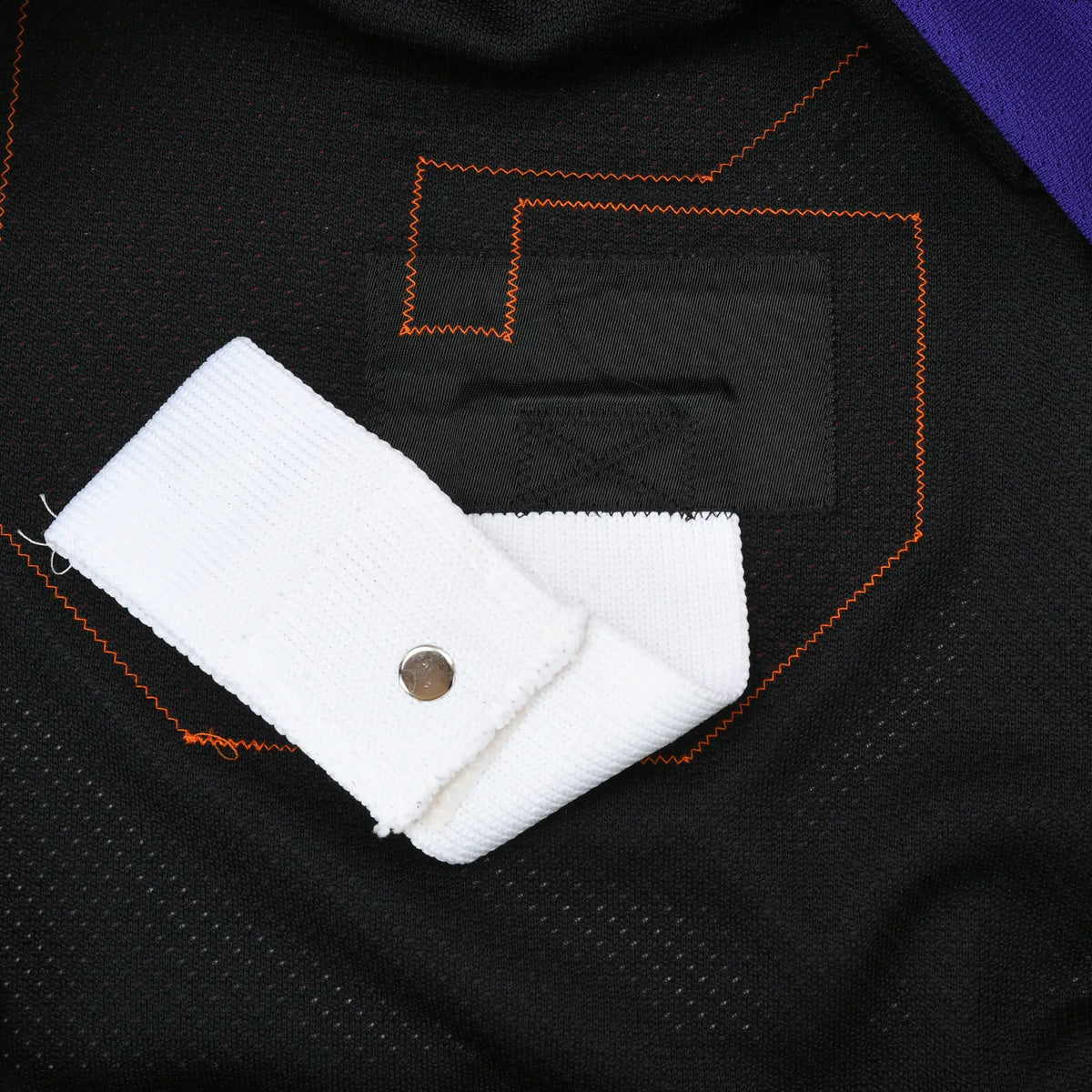 Interior detail of stitched number 9 with white fight strap and metal snap
