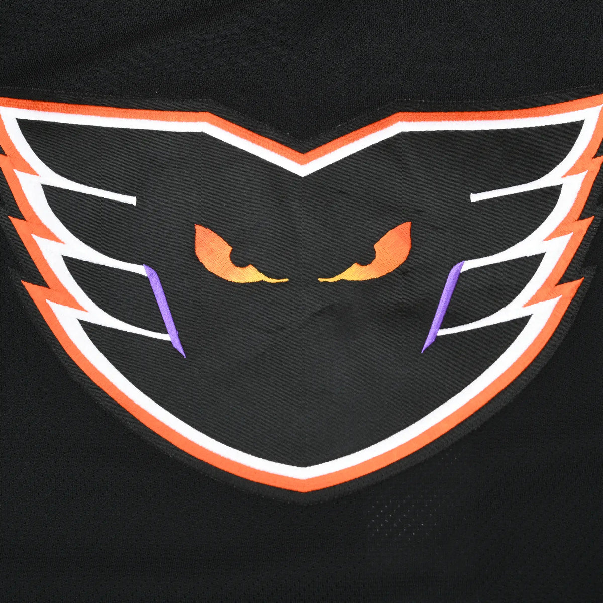 Close-up of Philadelphia Phantoms winged eyes logo on black jersey chest