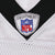 Close-up of embroidered NFL Equipment shield at black V-neck collar