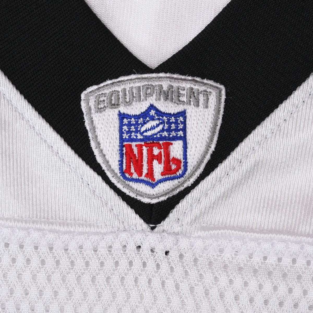 Close-up of embroidered NFL Equipment shield at black V-neck collar