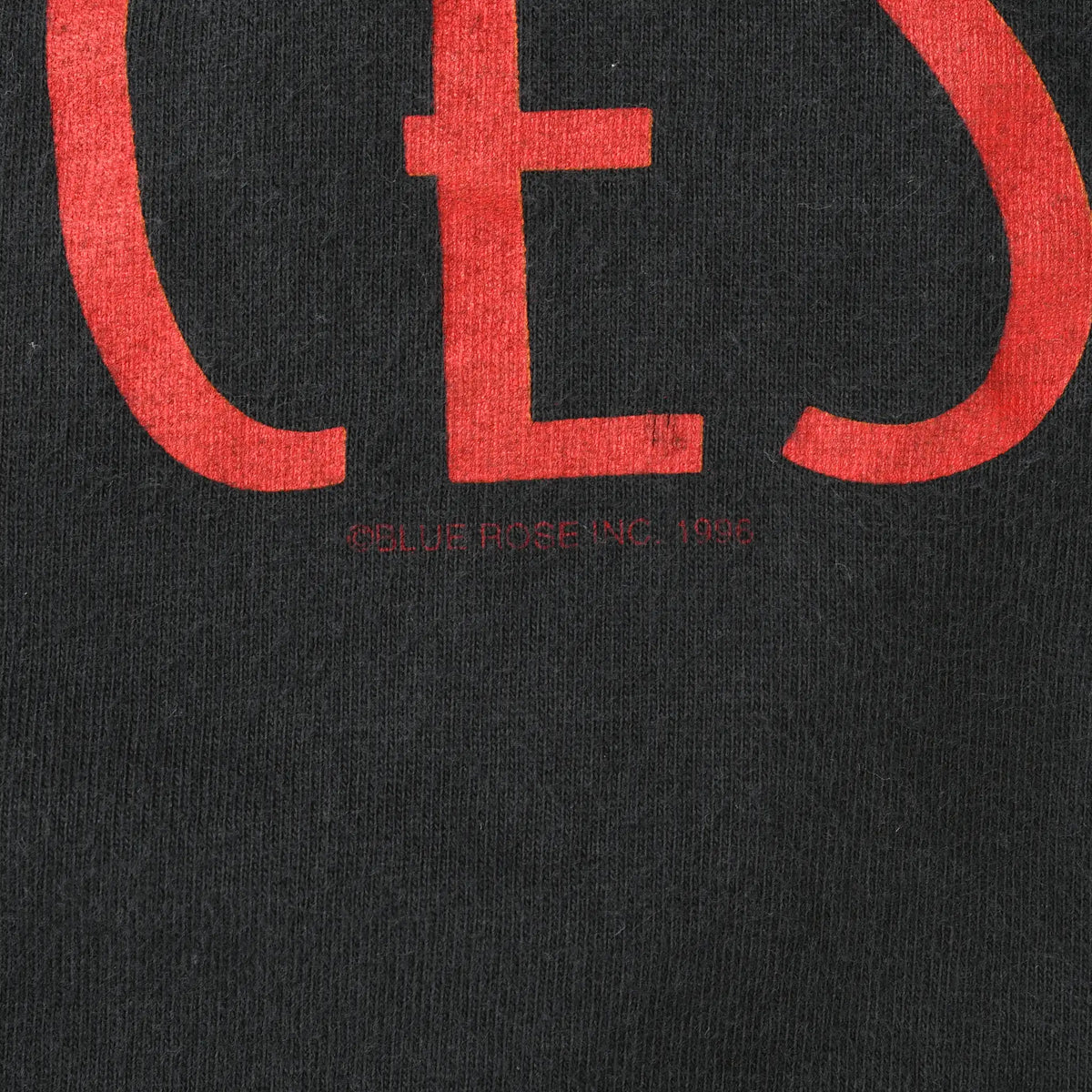 Close-up of small Belief Rose Inc. 1996 copyright text beneath red print