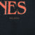 Close-up of cracked orange lettering and small copyright mark on black fabric