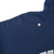 Close-up of a small red and white mark near the shoulder of the navy blue hoodie