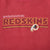 Close-up of embroidered Washington Redskins lettering, stripes, and team logo on burgundy fabric