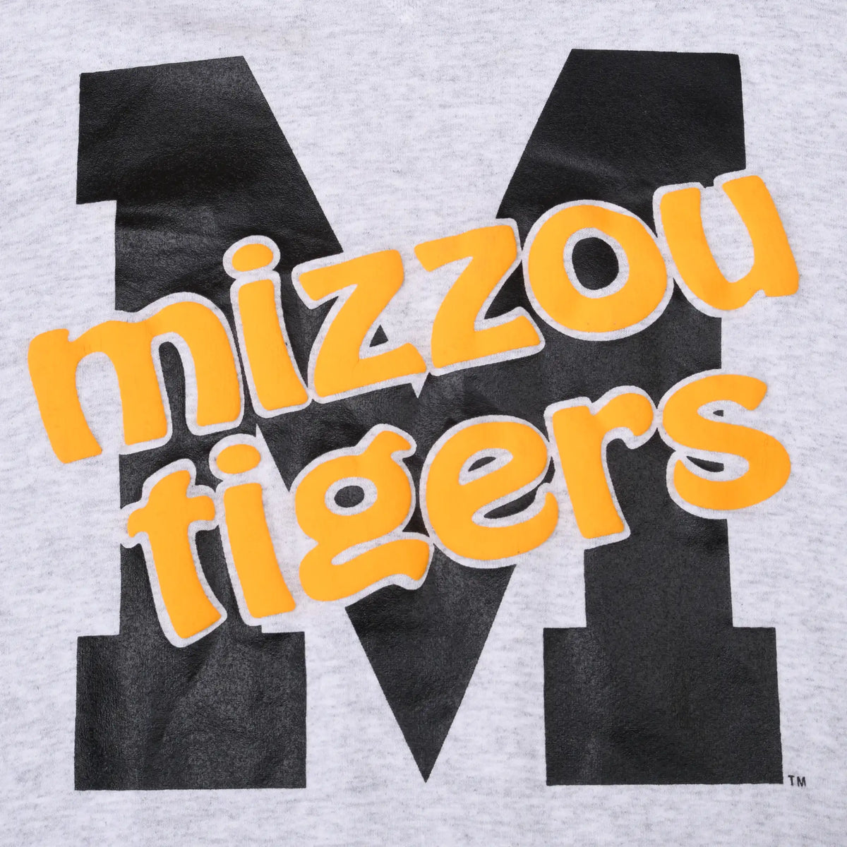 Close-up of yellow Mizzou Tigers lettering over a large black M print