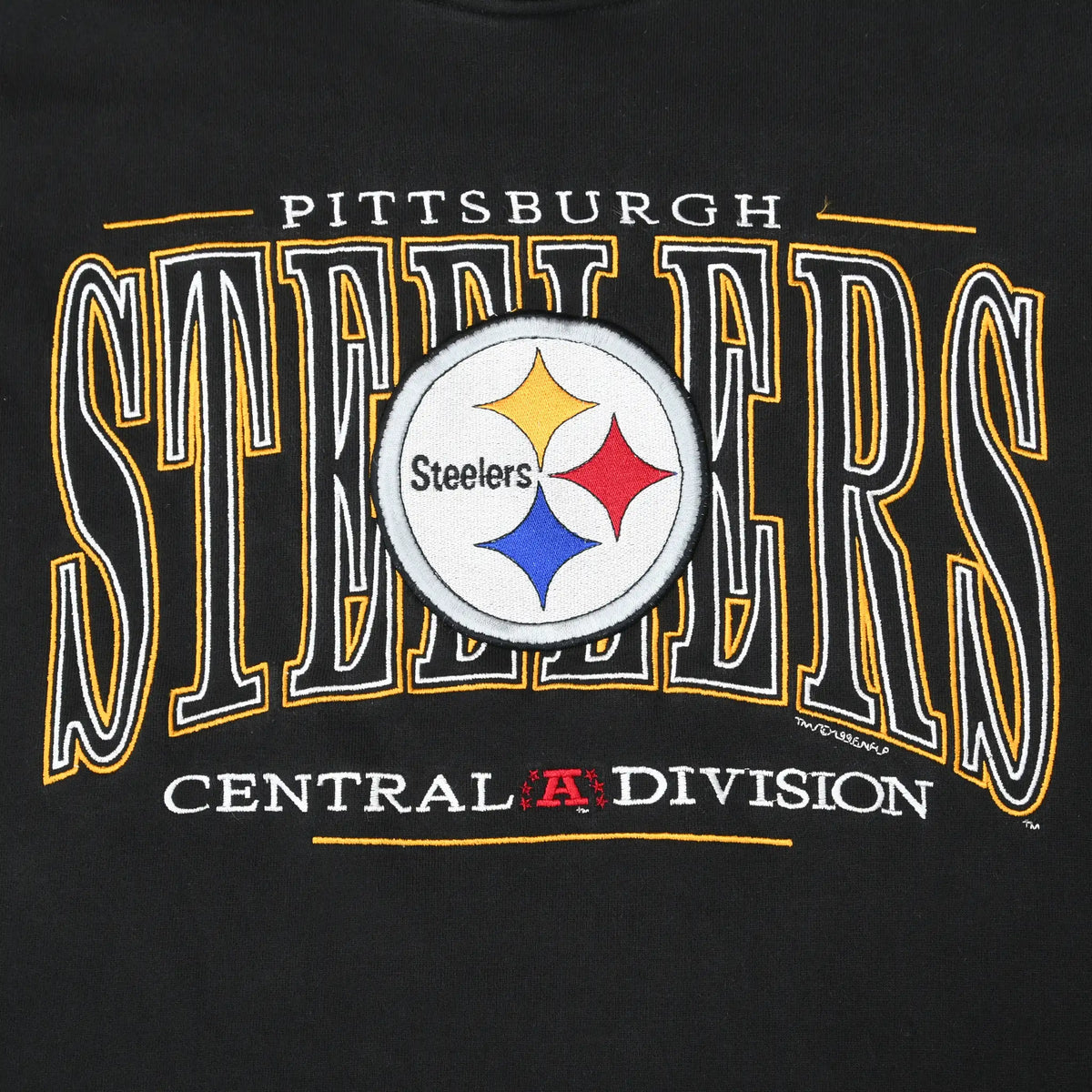 Close-up of embroidered Pittsburgh Steelers logo and Central Division chest graphic