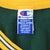Close-up of Champion neck label inside green jersey with yellow collar