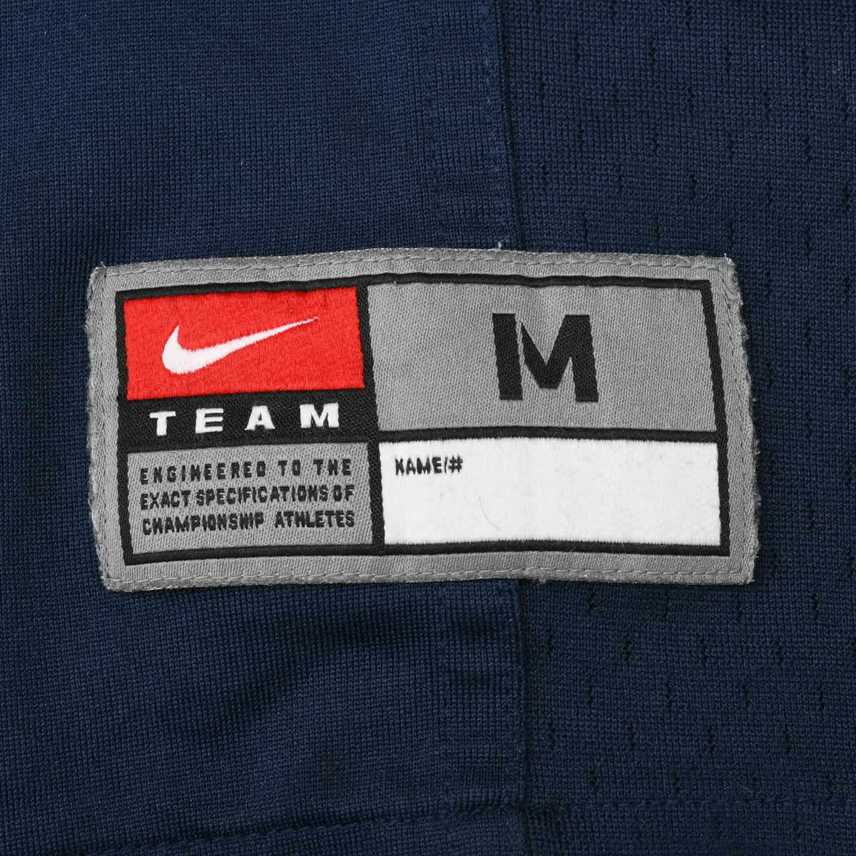 Nike Team medium jock tag stitched near the hem of navy BYU football jersey