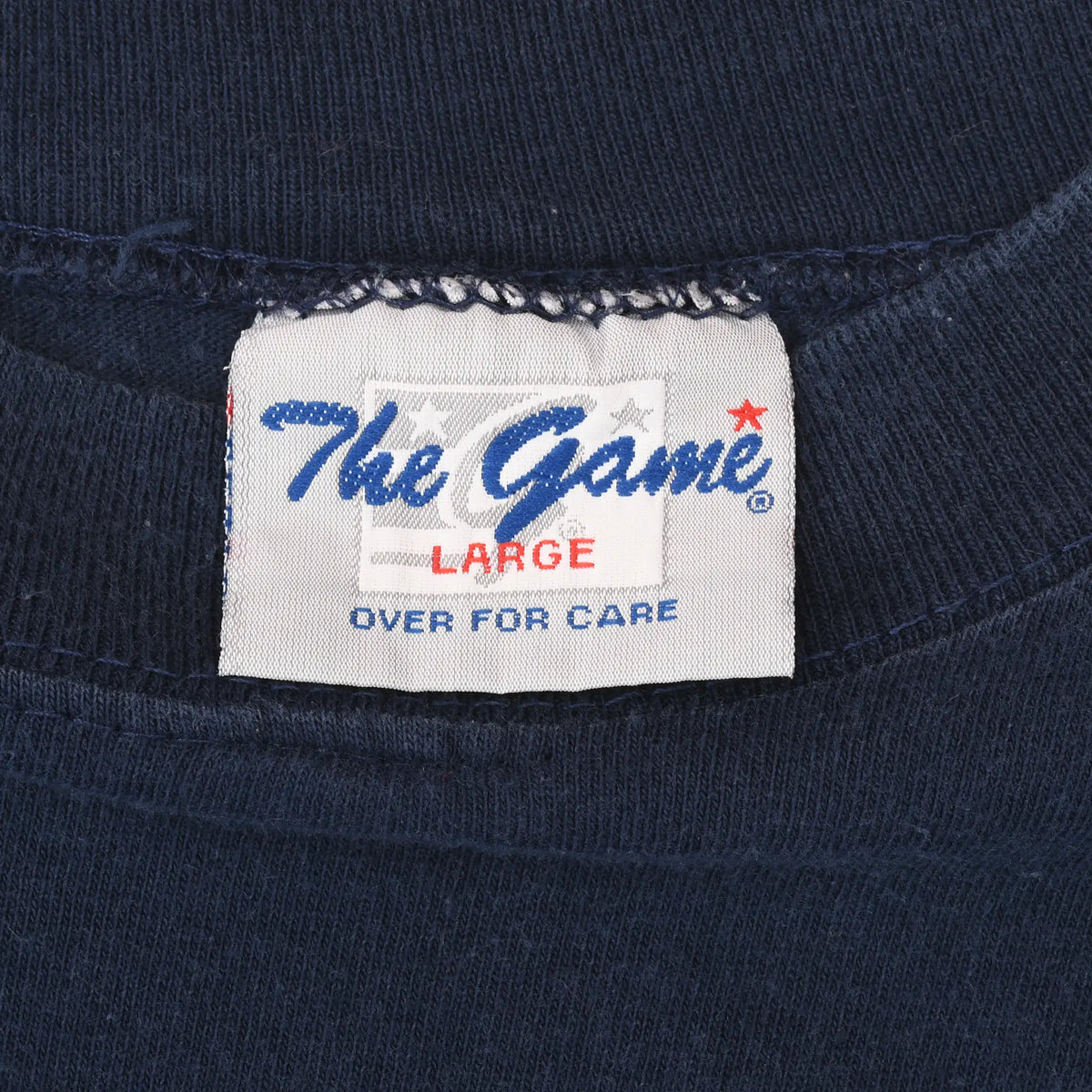 The Game neck tag marked Large and Over for Care on navy T-shirt