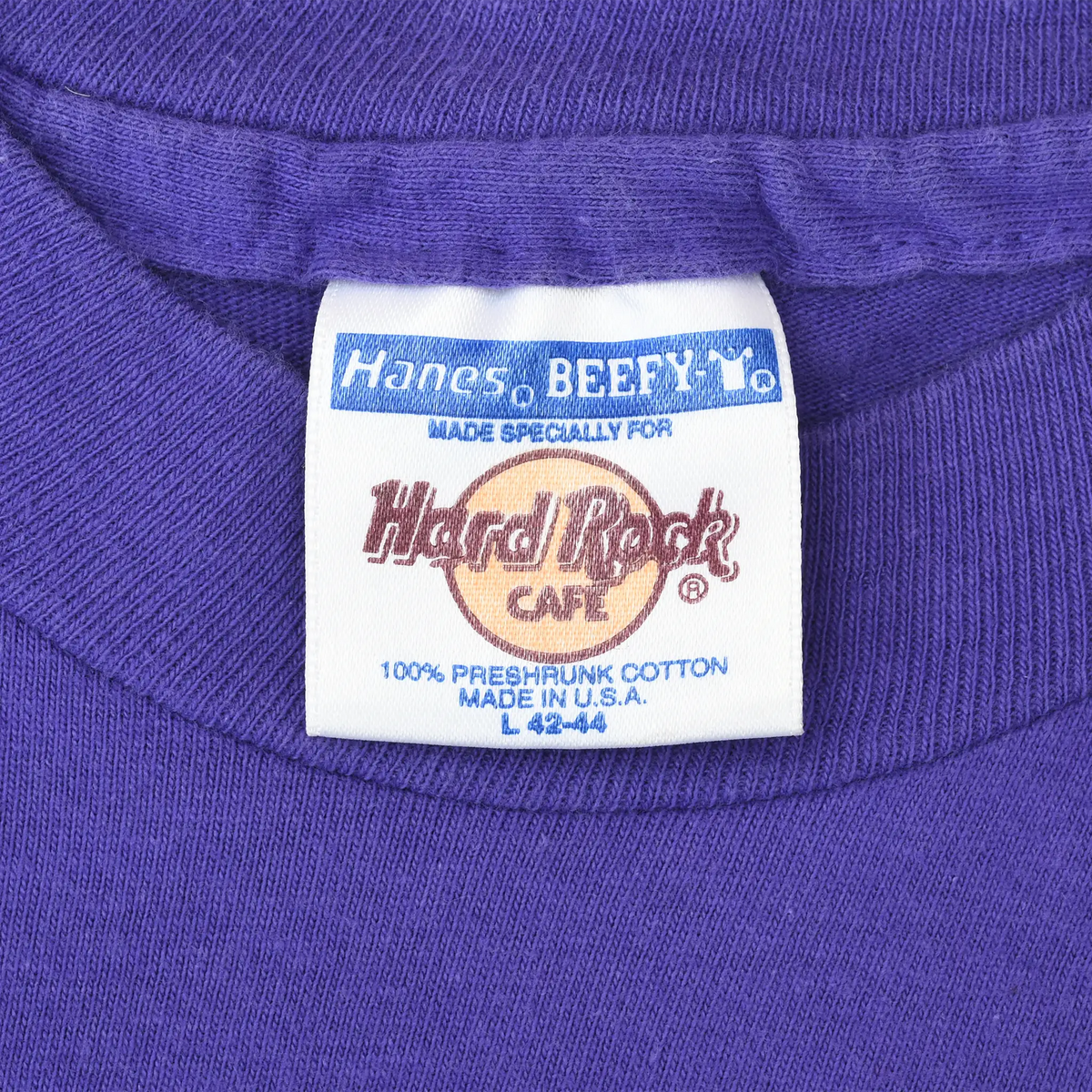Close-up of Hanes Beefy-T Hard Rock Cafe neck label on purple T-shirt