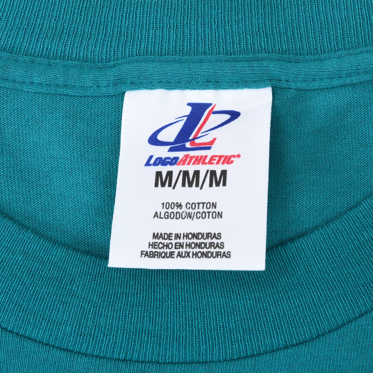 Close-up of Logo Athletic M neck label on teal T-shirt