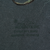 Close-up of blue-gray fabric with faint marks near the printed graphic