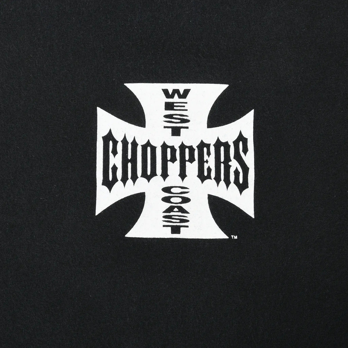 Close-up of white West Coast Choppers cross graphic on black fabric
