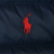 Close-up of red Polo pony embroidery on navy quilted jacket