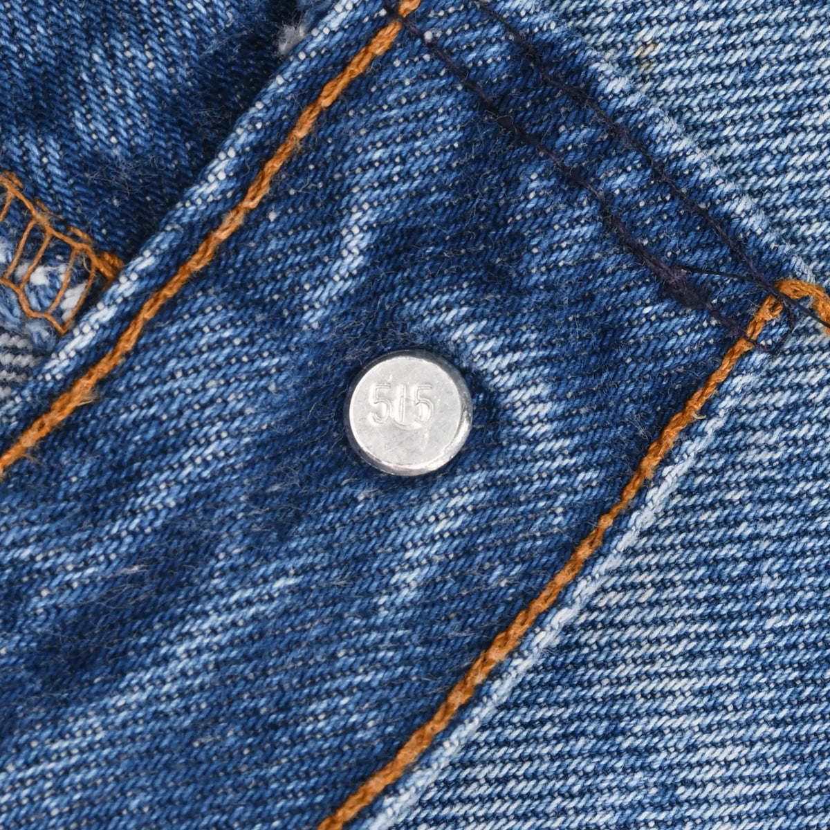 Close-up of metal button stamped 515 on Levi's blue jeans