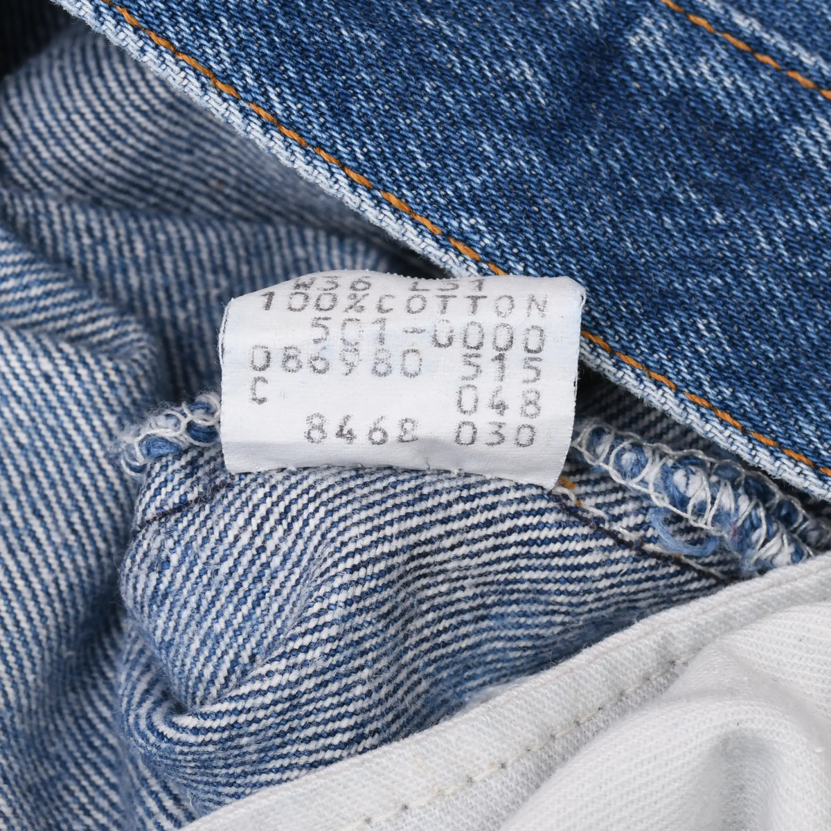 Close-up of interior Levi's production label printed with codes and 100% cotton