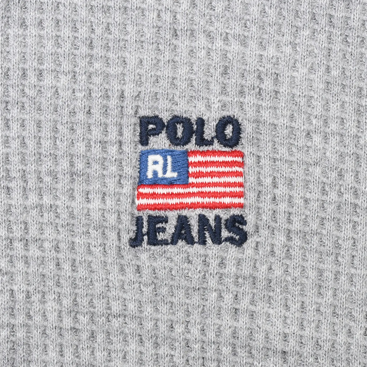 Close-up of Polo Jeans flag logo embroidery on grey waffle fabric