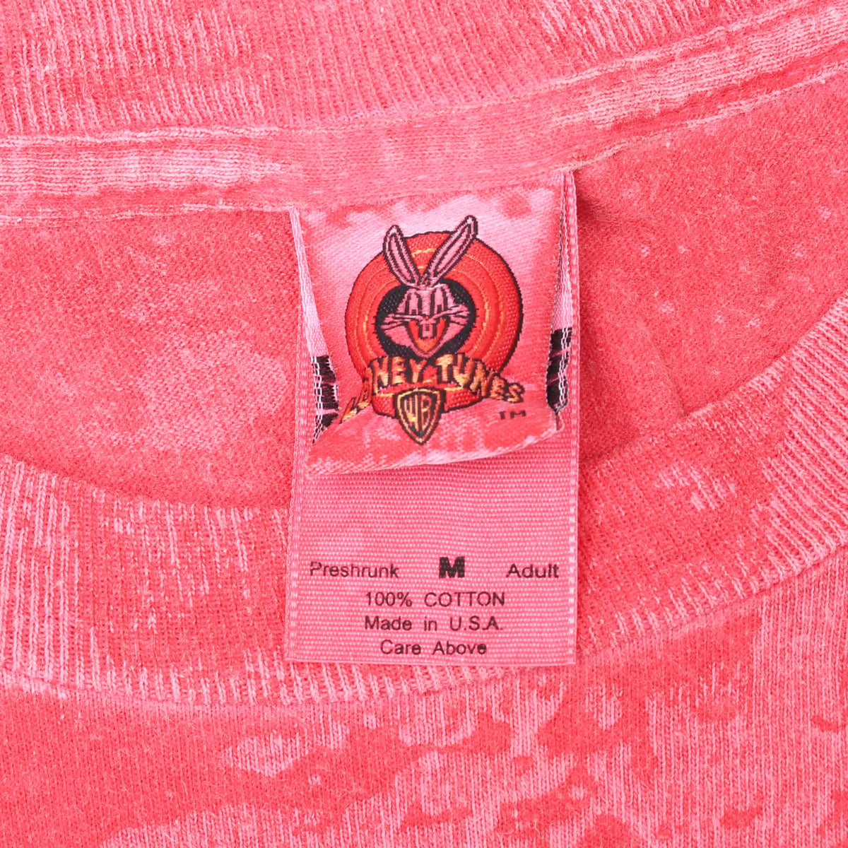 Close-up of Looney Tunes neck label marked medium, 100% cotton and Made in U.S.A.