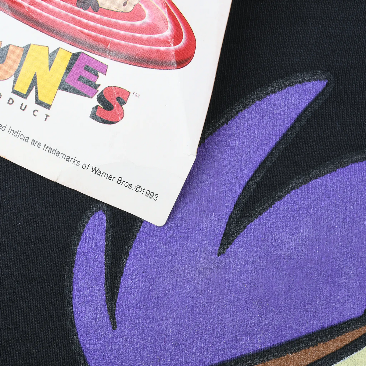 Close-up of purple screen print and Warner Bros. copyright text on Looney Tunes hangtag