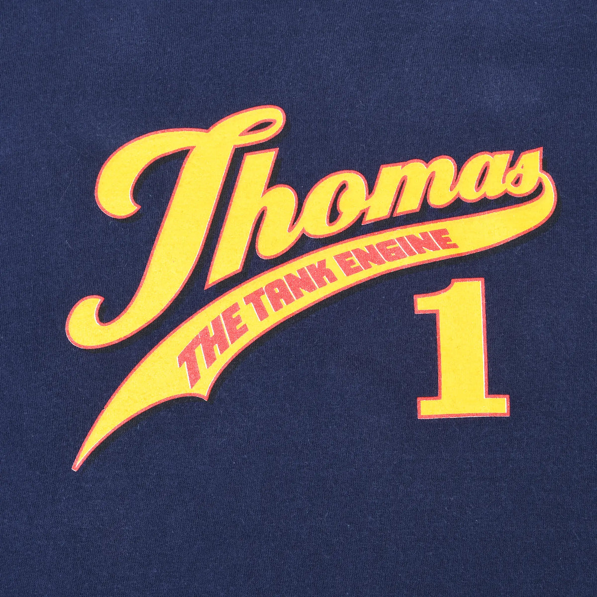 Close-up of yellow and red Thomas the Tank Engine 1 front print on navy fabric