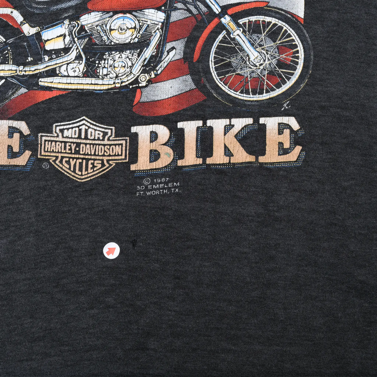 Close-up of lower front Harley-Davidson graphic and small hole in charcoal fabric