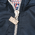 Close-up of the white front zipper and metal Pro Player logo pull on navy fabric