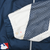 Close-up of white and navy mesh sleeve panel with small yellow discoloration near the cuff