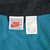 Close-up of Nike neck and care labels marked size XL against teal mesh lining