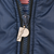 Close-up of metallic Pro Player logo zipper pull on navy jacket fabric