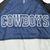 Close-up of large white-outlined COWBOYS lettering across navy jacket back