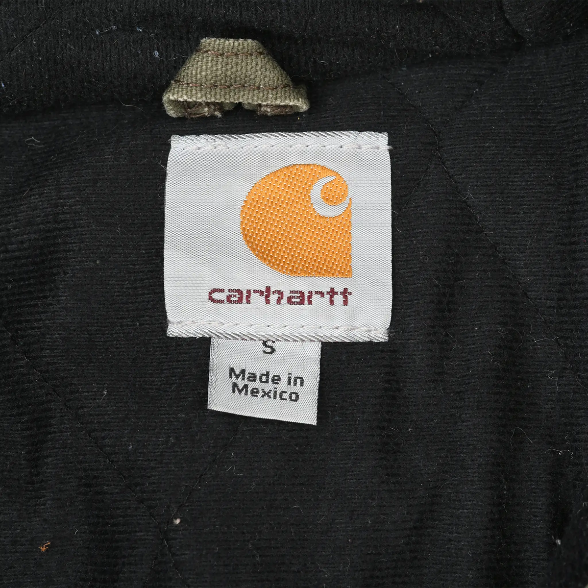 Carhartt neck label showing size S and Made in Mexico text against black lining