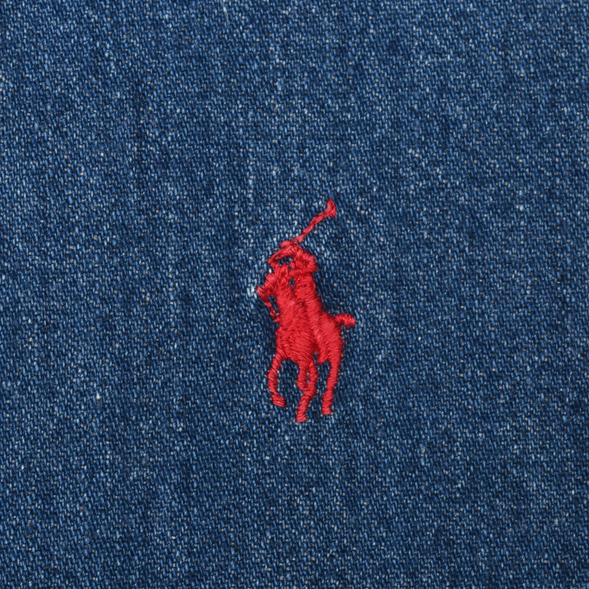 Close-up of red Ralph Lauren polo player embroidery on blue denim fabric