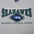 Close-up of embroidered Seattle Seahawks chest graphic in navy, green, blue, and white