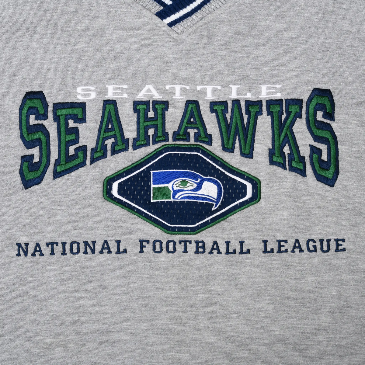 Close-up of embroidered Seattle Seahawks chest graphic in navy, green, blue, and white