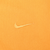 Close-up of tonal Nike Swoosh embroidery on yellow sweatshirt chest
