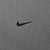Close-up of small black Nike Swoosh embroidery on khaki sweatshirt chest