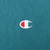 Close-up of red and white Champion logo embroidery on teal sweatshirt chest