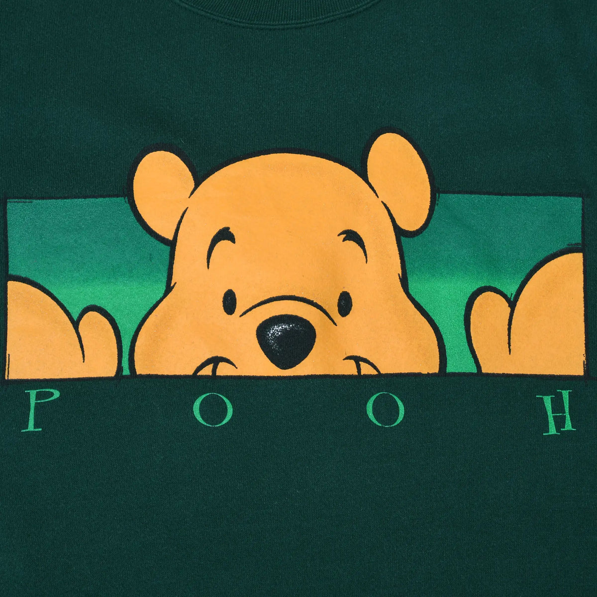 Close-up of Winnie the Pooh peeking graphic and spaced POOH lettering